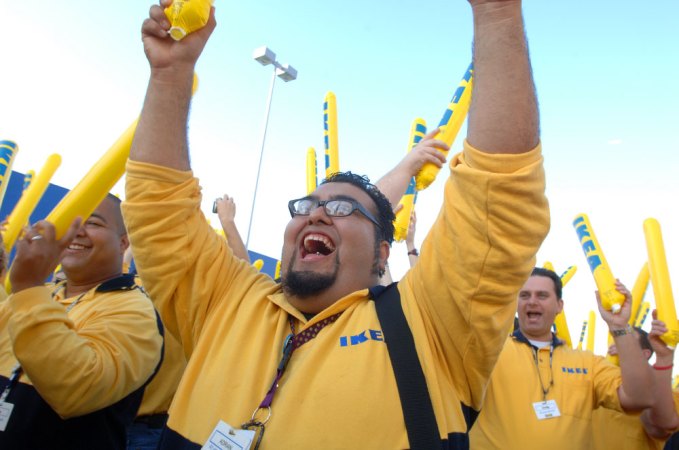 In this photo provided by IKEA, employee Adrian Gonzalez, center, of Burbank, Calif., helps pump up the crowd waiting to enter the new IKEA store during grand-opening ceremonies in Orlando, FL (AP Photo/Phelan M. Ebenhack, IKEA)
